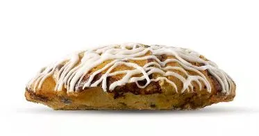 Close-up of a warm Chocolate Chip Muffin, a popular bakery side item from the 7 Brew menu.
